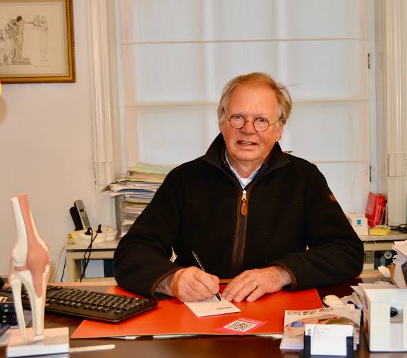 Dokter Geert Dewilde aan zijn bureau in de consultatieruimte